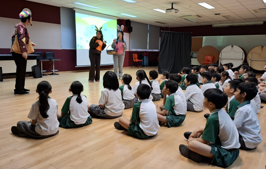 Students watching an interactive drama performance during an English lesson.